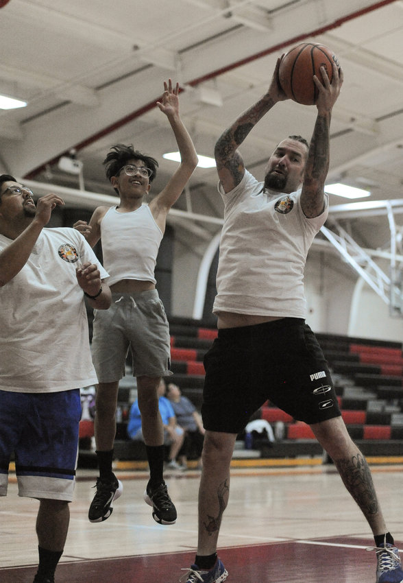 Prairie View High School resource officer Justin Stadler of the Brighton Police Department, snares a rebound during a 3-on-3 basketball game with area youth June 17 at Brighton High School. This is the second consecutive year that Brighton PD has held this event, which attempts to get area kids positively involved with the department.